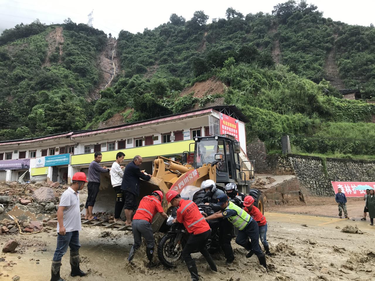 8月18日，搶險(xiǎn)人員與民警幫助被困群眾的摩托車(chē)通過(guò)涉水路面.jpg